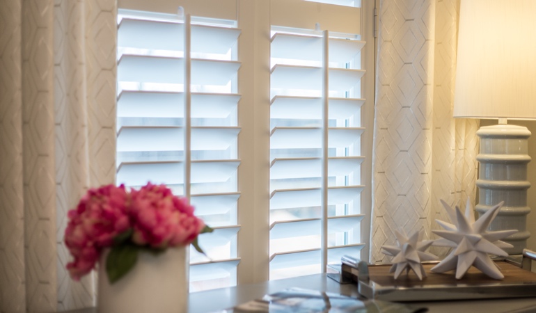 Plantation shutters by flowers in New Jersey