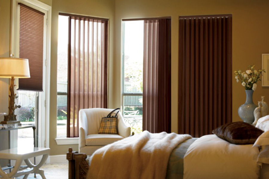 Choose durable and high-quality fabric or vinyl vertical blinds in New Jersey. Maroon fabric vertical blinds inside a bedroom